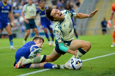 190825 - AFC Wimbledon v Cardiff City - Sky Bet League 1 - Joel Colwill of Cardiff City is challenged by Steve Seddon of Wimbledon