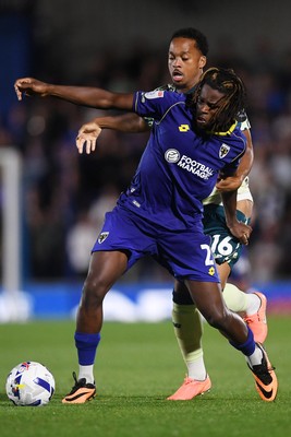 190825 - AFC Wimbledon v Cardiff City - Sky Bet League 1 - Chris Willock of Cardiff City is challenged by Nathan Asiimwe of Wimbledon