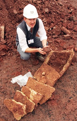 151195 - Ancient Coffin, Caerleon - Archaeologist Dr Ray Howell with part of the uncovered stone coffin and a bowl found with it 