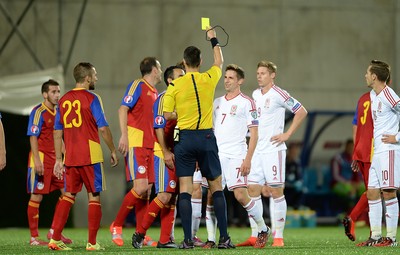 090914 - Andorra v Wales - 2016 Euro Qualifier -Referee Slavko Vincic shows Joe Allen of Wales a yellow card