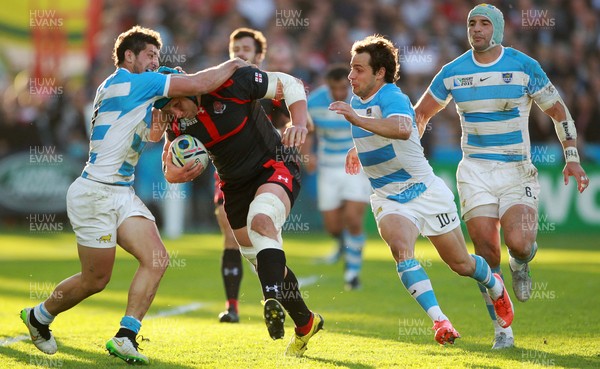 250915 - Argentina v Georgia - Rugby World Cup - Levan Datunashvili of Georgia is tackled by Tomas Cubelli and Nicolas Sanchez of Argentina