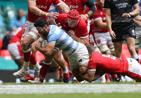 100721 - Argentina v Wales, Summer International First Test - Jeronimo de la Fuente of Argentina is tackled by Kieran Hardy of Wales and James Botham of Wales