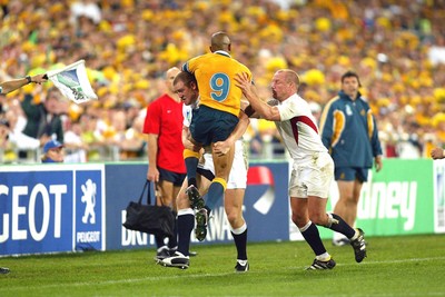 221103 - Australia v England - Rugby World Cup Final - England's Mike Tindall tackles George Gregan with help from Neil Back