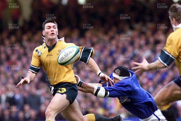 061199 - Australia v France - Rugby World Cup Final -  Daniel Herbert of Australia is tackled by Abdelatif Benazzi