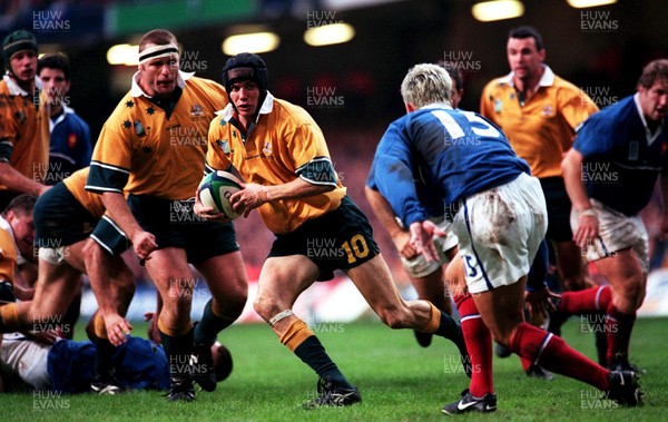 061199 - Australia v France - Rugby World Cup Final -  Stephen Larkham of Australia takes on Xavier Garbajosa