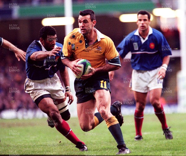 061199 - Australia v France - Rugby World Cup Final -  Joe Roff of Australia shakes off the tackle of France's Emile Ntamack 