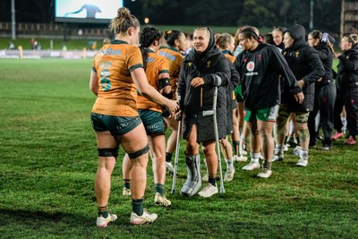 010825 - Australia Women v Wales Women - Alex Callender of Wales on crutches congratulates the Australian team