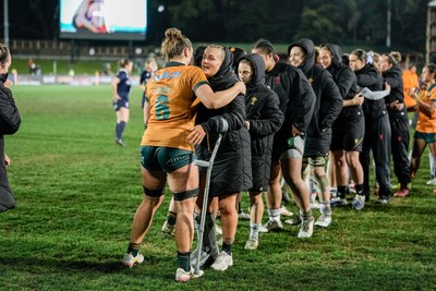 010825 - Australia Women v Wales Women - Alex Callender of Wales on crutches congratulates the Australian team