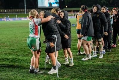 010825 - Australia Women v Wales Women - Alex Callender of Wales on crutches is embraced by Molly Reardon of Wales at the end of the match