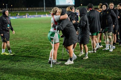 010825 - Australia Women v Wales Women - Alex Callender of Wales on crutches is embraced by Molly Reardon of Wales at the end of the match