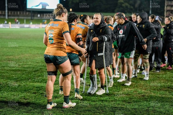 010825 - Australia Women v Wales Women - Alex Callender of Wales on crutches congratulates the Australian team