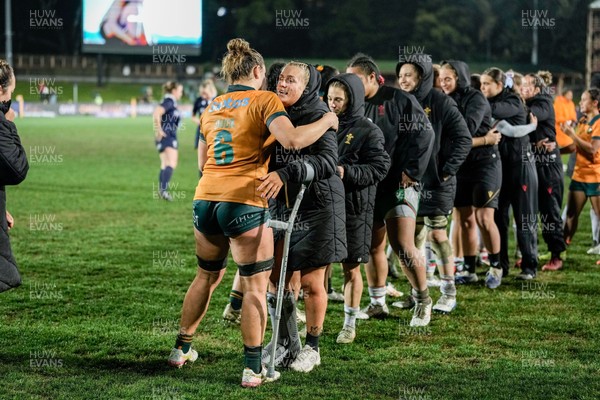 010825 - Australia Women v Wales Women - Alex Callender of Wales on crutches congratulates the Australian team