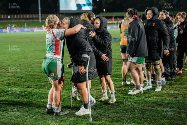 010825 - Australia Women v Wales Women - Alex Callender of Wales on crutches is embraced by Molly Reardon of Wales at the end of the match