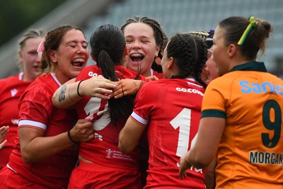 260725 - Australia Women v Wales Women - Nel Metcalfe of Wales is congratulated by Georgia Evans of Wales and Maisie Davies of Wales after she powers over to score try