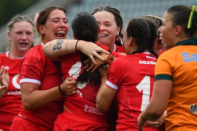 260725 - Australia Women v Wales Women - Nel Metcalfe of Wales is congratulated by Georgia Evans of Wales and Maisie Davies of Wales after she powers over to score try
