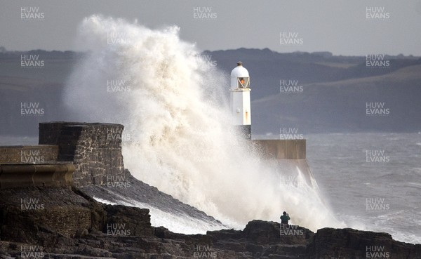 160118 - Picture shows a man walking on the rocks as the windy weather hits the South Wales coast at Porthcawl
