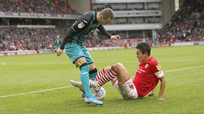 191019 - Barnsley v Swansea City - Sky Bet Championship - Kenny Dougall of Barnsley wraps himself round Besant Celina of Swansea in the 2nd half