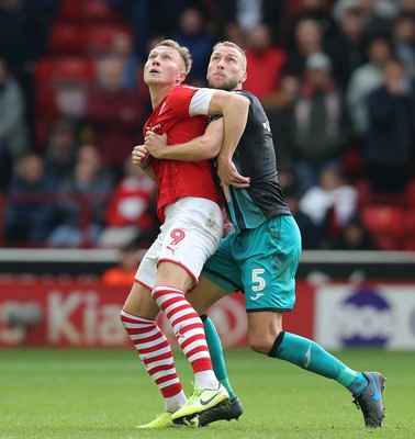 191019 - Barnsley v Swansea City - Sky Bet Championship - Cauley Woodrow of Barnsley and Mike Van der Hoorn  of Swansea wait for the high cross