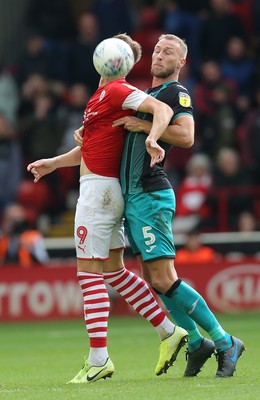 191019 - Barnsley v Swansea City - Sky Bet Championship - Cauley Woodrow of Barnsley and Mike Van der Hoorn  of Swansea wait for the high cross