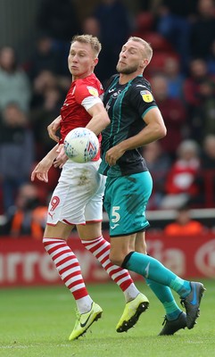 191019 - Barnsley v Swansea City - Sky Bet Championship - Cauley Woodrow of Barnsley and Mike Van der Hoorn  of Swansea wait for the high cross