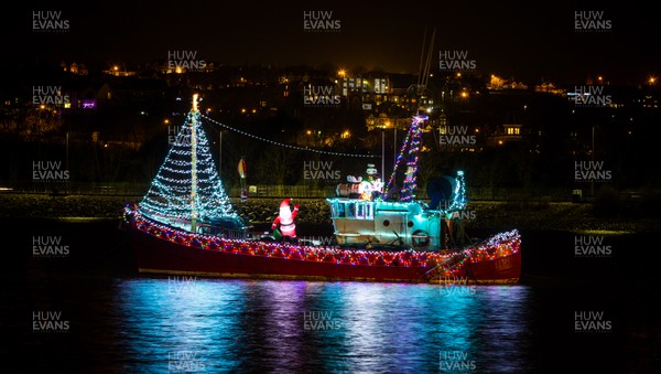 131220 - An inflatable Santa waves out from a boat in the harbour at Barry Island, South Wales, as it is decked out with Christmas lights in the run up to Christmas