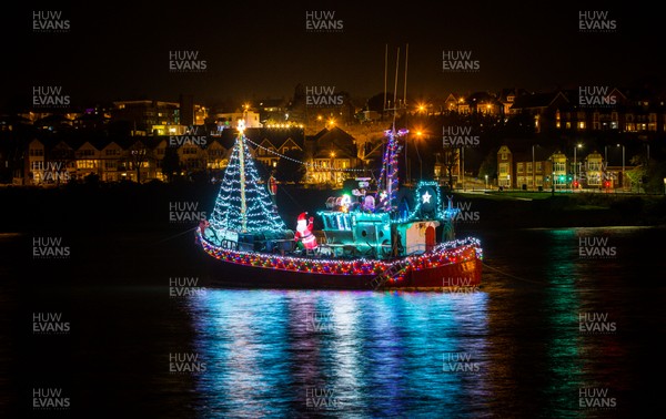 131220 - An inflatable Santa waves out from a boat in the harbour at Barry Island, South Wales, as it is decked out with Christmas lights in the run up to Christmas