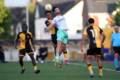 250725 - Barry Town United v Newport County - Pre Season Friendly - Armani Babah of Newport County challenges for a header