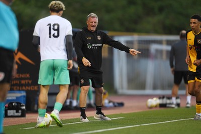 250725 - Barry Town United v Newport County - Pre Season Friendly - Newport County Assistant Manager, Wayne Hatswell leads the dugout