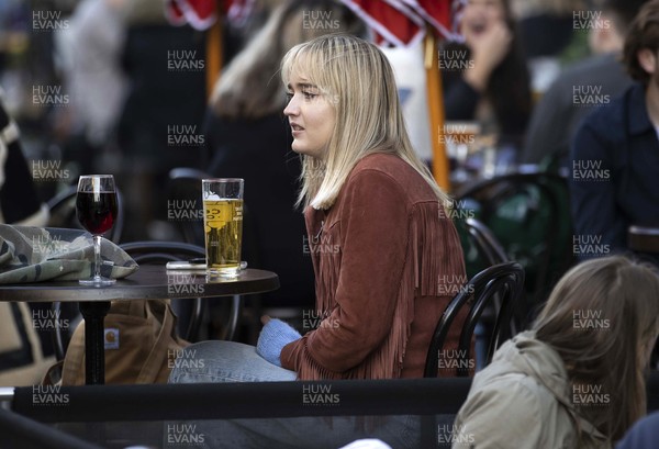 260421 - Picture shows people in Cardiff, South Wales enjoying being able to return to the pub today, as coronavirus restrictions are eased allowing outdoor hospitality to reopen