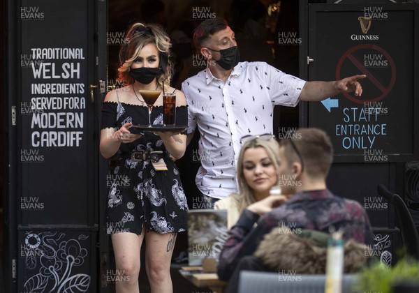260421 - Picture shows people in Cardiff, South Wales enjoying being able to return to the pub today, as coronavirus restrictions are eased allowing outdoor hospitality to reopen