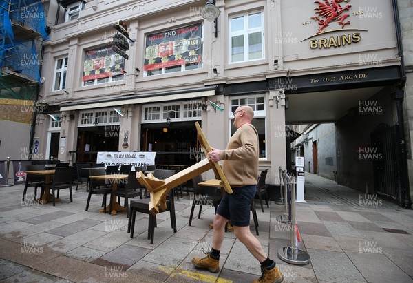 260421 Bars and restaurants reopen, Wales - Staff at The Old Arcade pub in Cardiff prepare to open as bars and restaurants in Wales are allowed to serve customers outdoors after a lifting of Welsh Government COVID-19 restrictions today