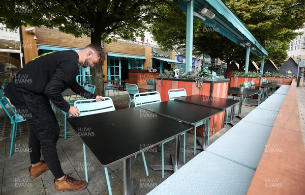 260421 Bars and restaurants reopen, Wales - Staff at Las Iguanas in Cardiff prepare to open as bars and restaurants in Wales are allowed to serve customers outdoors after a lifting of Welsh Government COVID-19 restrictions today