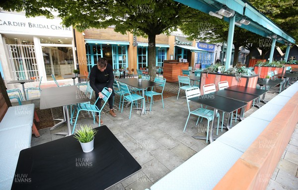 260421 Bars and restaurants reopen, Wales - Staff at Las Iguanas in Cardiff prepare to open as bars and restaurants in Wales are allowed to serve customers outdoors after a lifting of Welsh Government COVID-19 restrictions today