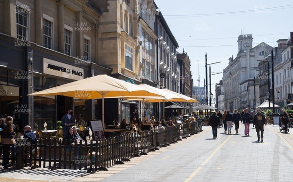 260421 Bars and restaurants reopen, Wales - Staff at bars and restaurants in Cardiff welcome customers back as they are allowed to serve customers outdoors after a lifting of Welsh Government COVID-19 restrictions today