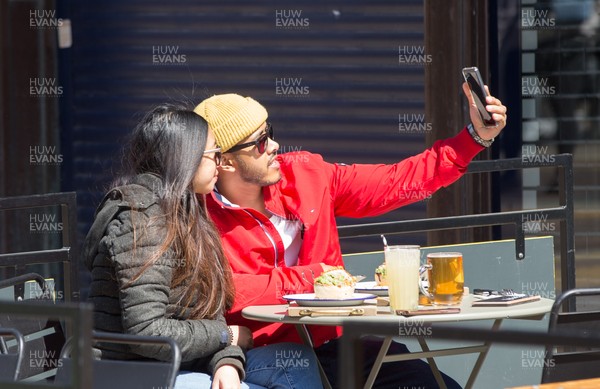 260421 Bars and restaurants reopen, Wales - A couple take a selfie at a restaurant in Cardiff after a lifting of Welsh Government COVID-19 restrictions today allowing the establishments to serve food and drink outdoors