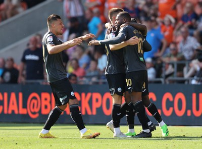 130822 - Blackpool v Swansea City - Sky Bet Championship - Olivier Ntcham of Swansea celebrates scoring the 1st goal of the match with assister Michael Obafemi, Cameron Congreve and Joel Piroe