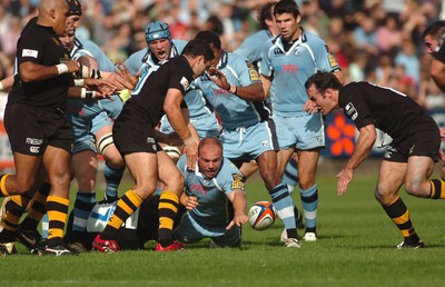 300906 - Cardiff Blues v London Wasps - EDF Energy Cup - Cardiff Arms Park - Cardiff Blues' Mark Lewis loses the ball as he is tackled by Eoin Reddan 