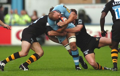 300906 - Cardiff Blues v London Wasps - EDF Energy Cup - Cardiff Arms Park - Blues' Mark Lewis is sandwiched by the Wasps defence 