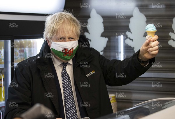 030521 - Picture shows Prime Minister Boris Johnson serving ice cream whilst visiting Marco�s cafe in Barry Island, South Wales on Bank Holiday Monday
