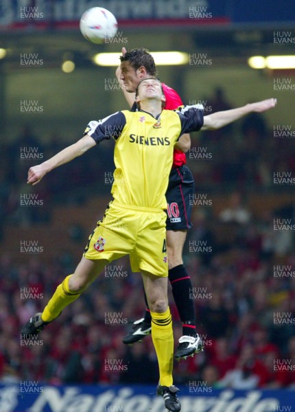 240503 - Bournemouth v Lincoln City - Third Division Play-Off Final - Lincoln's Ben Futcher battles with Steve Fletcher for the high ball