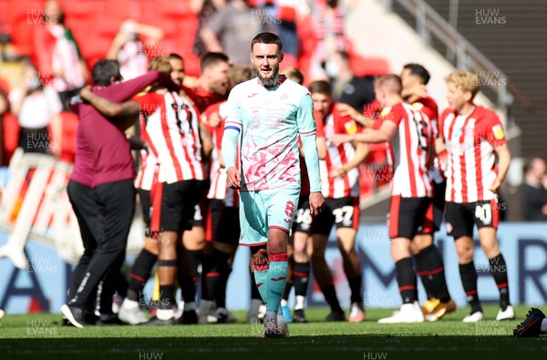 290521 - Brentford v Swansea City - SkyBet Championship Play off Final - Matt Grimes of Swansea City looks dejected as Brentford players celebrate at full time