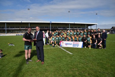 260425 - Bridgend Athletic v Skewen - Admiral National League 1 West Central - Kerry Frey of the WRU presents Bridgend Athletic Captain Jonathan Phillips with the trophy