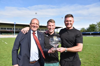 260425 - Bridgend Athletic v Skewen - Admiral National League 1 West Central - Kerry Frey of the WRU presents Bridgend Athletic Captain Jonathan Phillips and sponsor, Harry Griffiths with the trophy