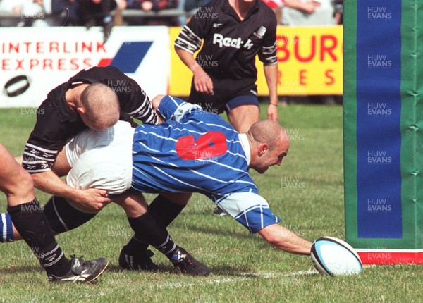 210996 - Bridgend v Neath - Wayne Morris of Bridgend dives over for try despite a tackle from Huw Woodland