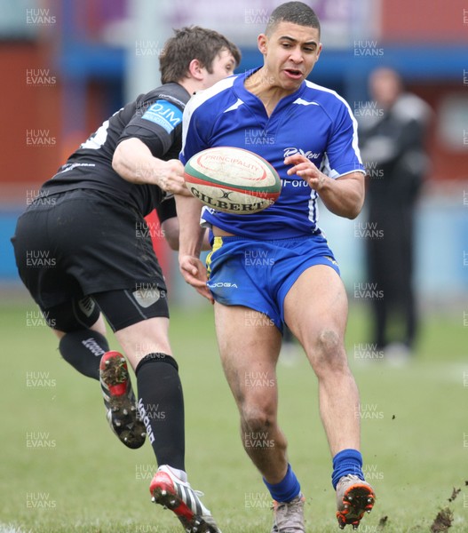 230213 - Bridgend v Neath, Principality Premiership - Bridgend's Glen Lewis looks to take the ball as Neath's David Langdon challenges