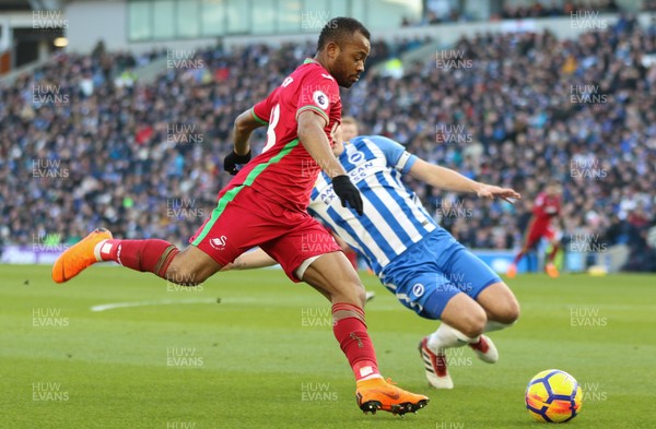 240218 - Brighton and Hove Albion v Swansea City, Premier League - Jordan Ayew of Swansea City is challenged by Lewis Dunk of Brighton