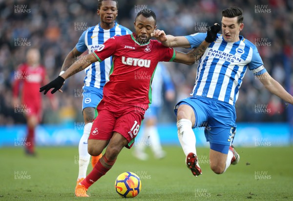 240218 - Brighton and Hove Albion v Swansea City, Premier League - Jordan Ayew of Swansea City is is tackled by Lewis Dunk of Brighton