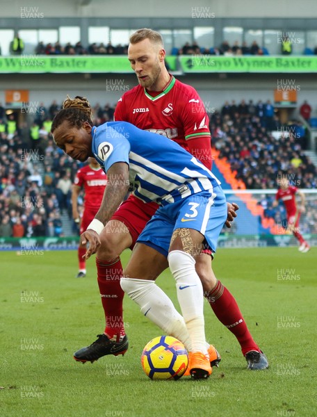 240218 - Brighton and Hove Albion v Swansea City, Premier League - Mike van der Hoorn of Swansea City challenges Gaetan Bong of Brighton as he looks to win the ball