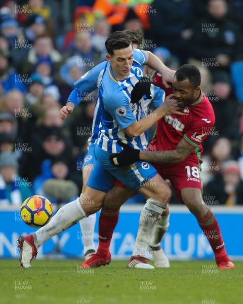 240218 - Brighton and Hove Albion v Swansea City, Premier League - Jordan Ayew of Swansea City is forced off the ball by Lewis Dunk of Brighton