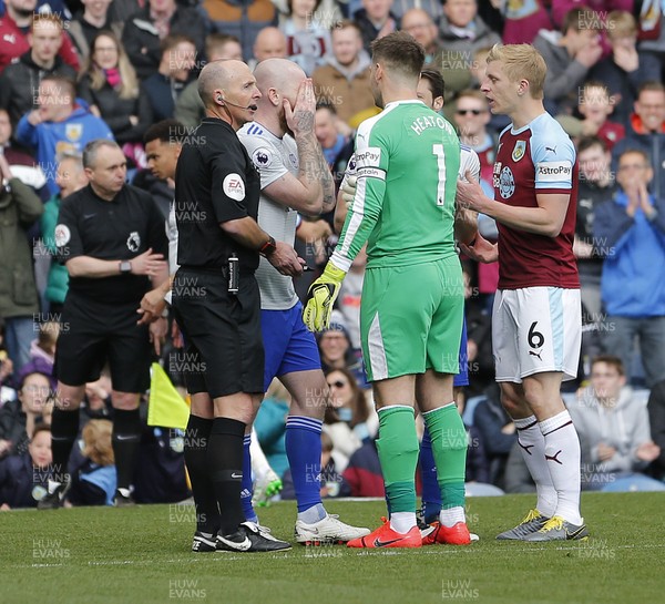 130419 - Burnley v Cardiff City - Premier League -  Aron Gunnarsson of Cardiff reacts as referee Mike Dean reverses a penalty decision as goalkeeper Thomas Heaton and Ben Mee of Burnley speak to him